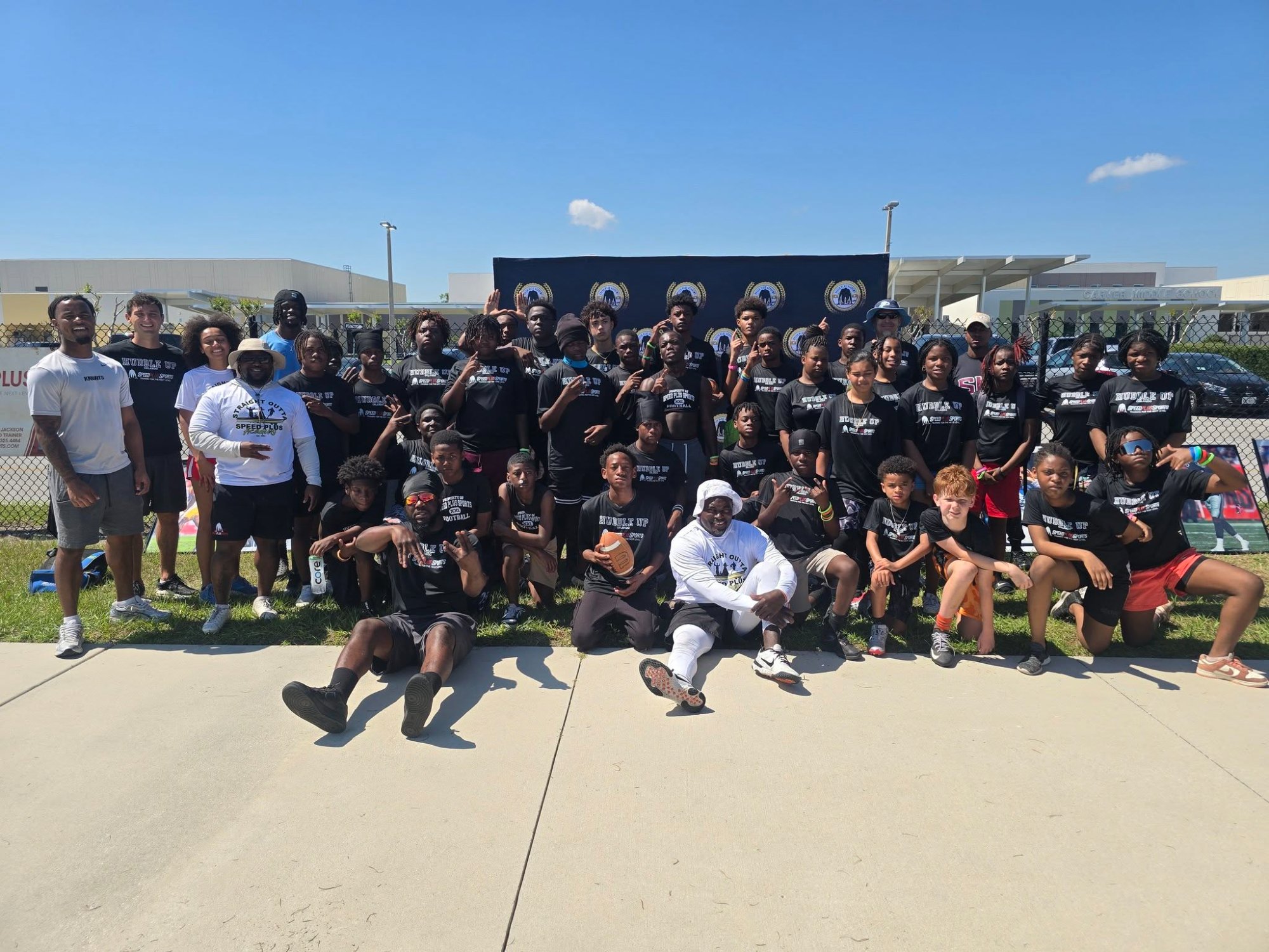 Large group of Speed Plus Academy youth in black Huddle Up shirts