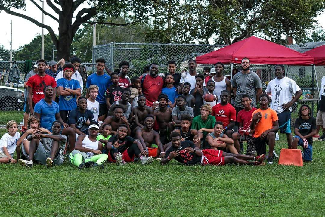Large group of youth athletes and coaches on grass